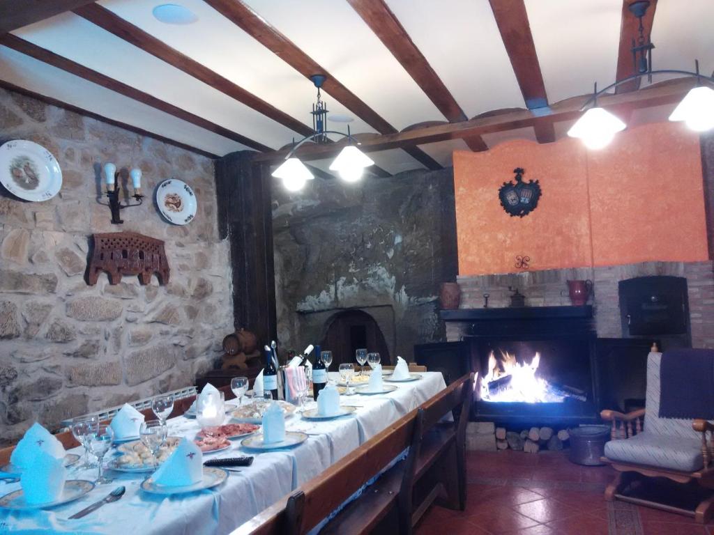 a dining room with a long table and a fireplace at Casa junto a Haro y Miranda de Ebro con aire acondicionado wifi libre y barbacoa ,en un pueblo con encanto in Sajazarra