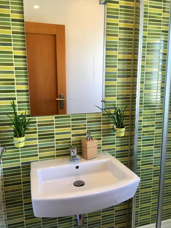 a bathroom with a sink and two potted plants at Âncora Boutique Apartments in Lagos