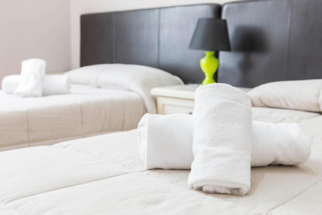 a pile of towels on a bed in a room at Albachiara Guest House in Rome