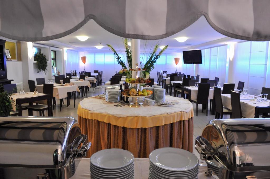 uma sala de jantar com uma mesa com pratos e cadeiras em Al Fogher em Treviso