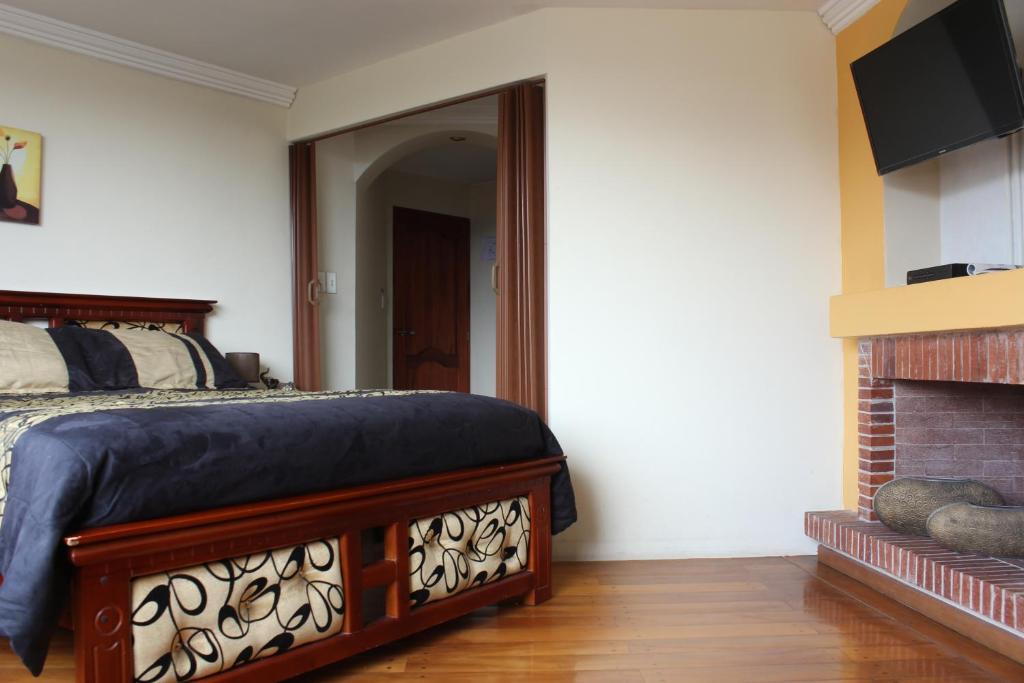 1 dormitorio con 1 cama y chimenea en Altura Rooms & Suites, en Quito