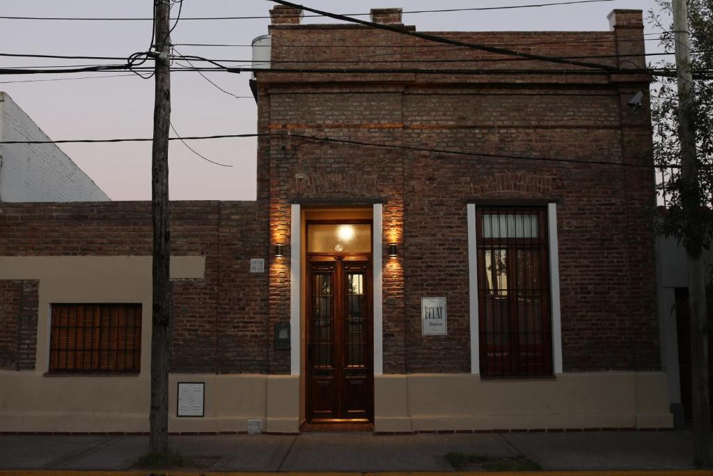 un edificio de ladrillo con una puerta en una calle en Eclat Suites Hotel Boutique en Villa Mercedes