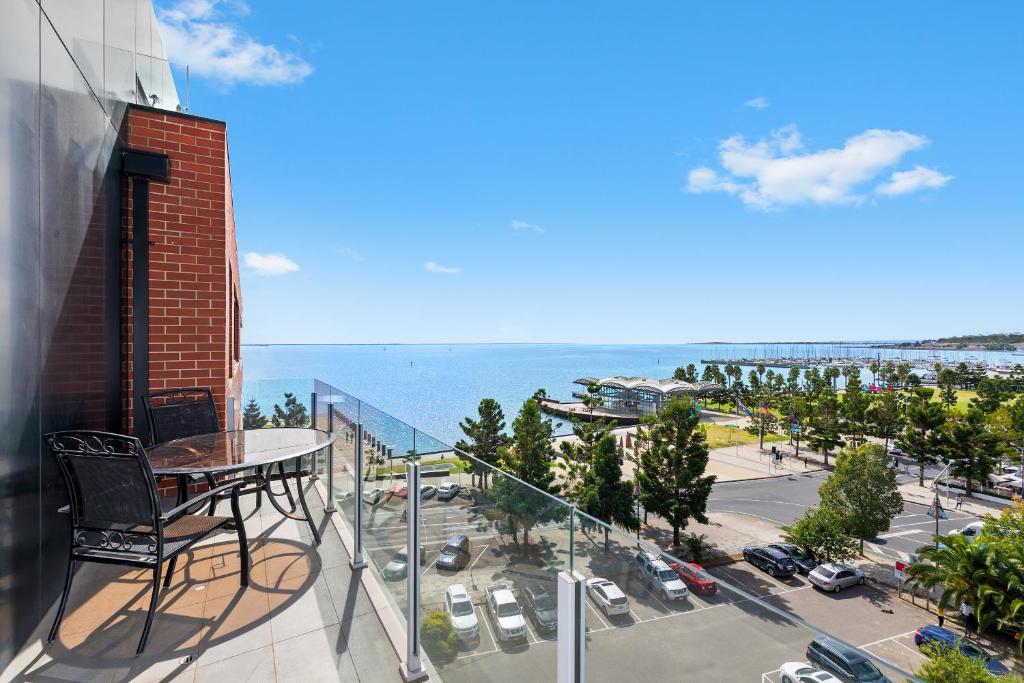 a balcony with a table and a view of a city at Pier Point 105 in Geelong