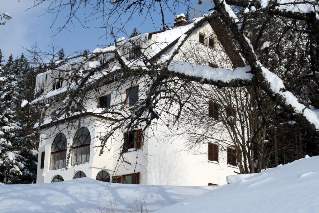 um edifício branco na neve com árvores cobertas de neve em Villa Kostic Kopaonik em Kopaonik