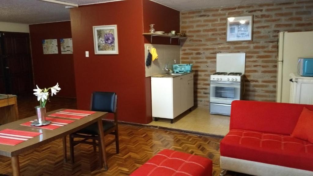 a living room with a table and a kitchen at Apartamento independiente a 6 minutos de Mall el Jardín in Quito