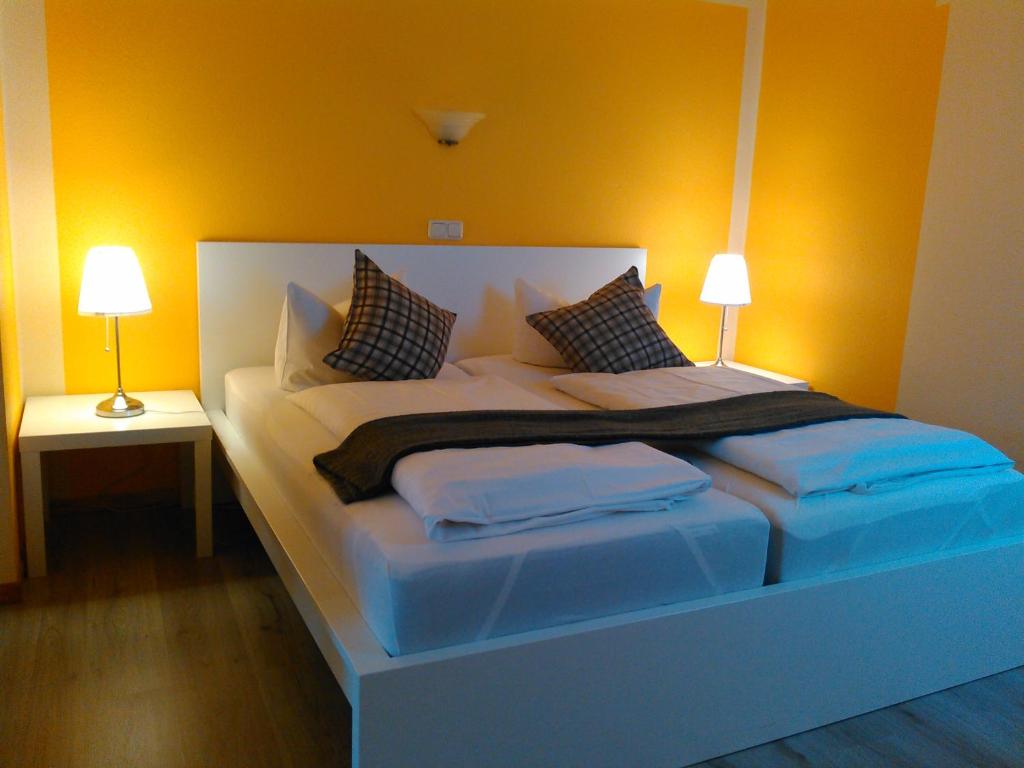 a large bed in a room with two lamps at Landhotel Possendorf in Weimar