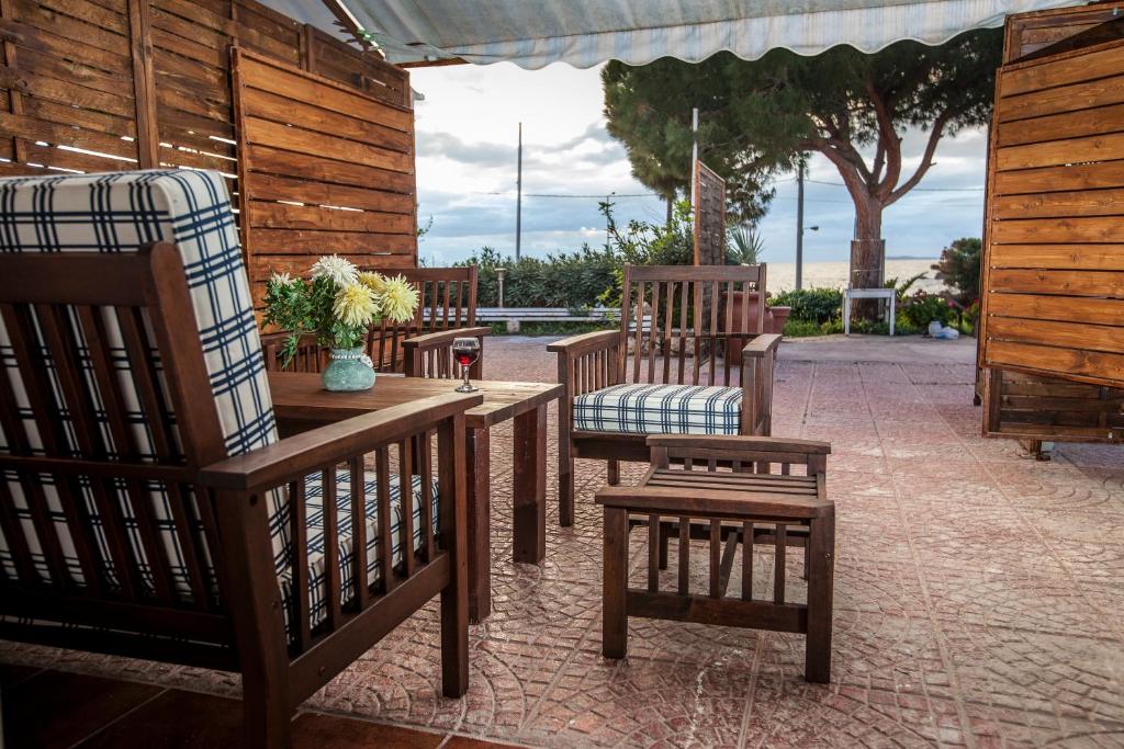 a group of benches and chairs on a patio at me gusta suite by the sea in Anavyssos