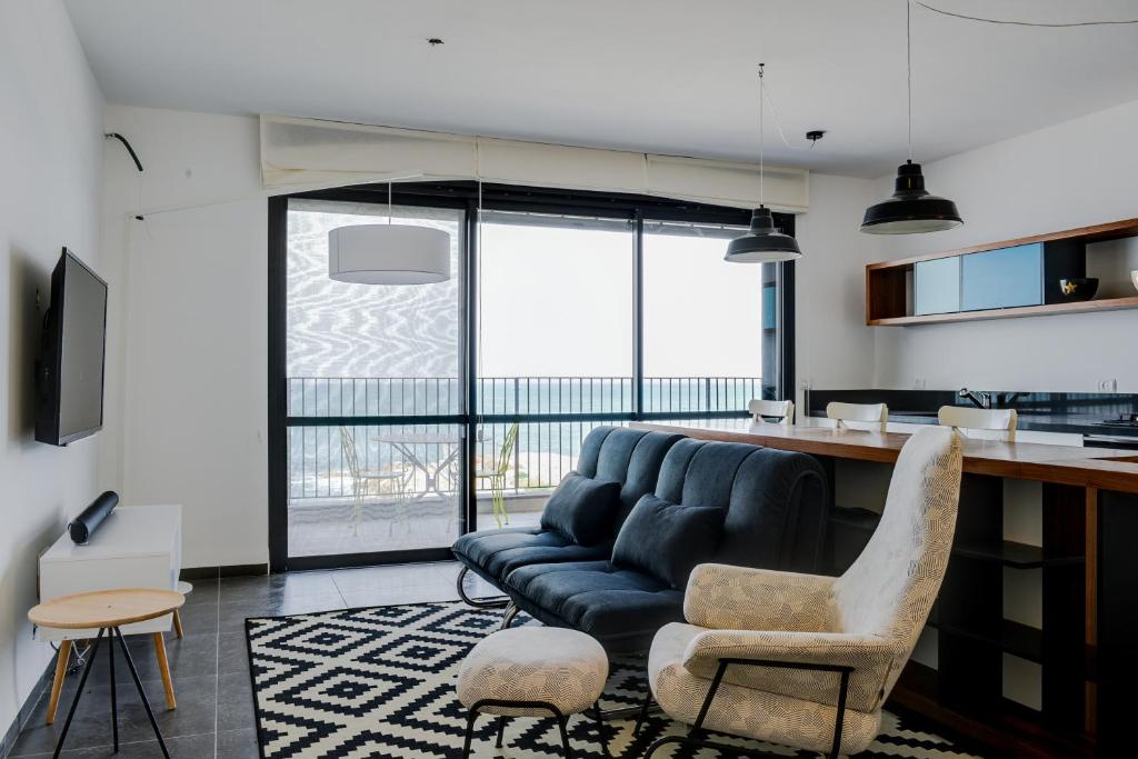 ein Wohnzimmer mit einem Sofa und einem Tisch in der Unterkunft Beautiful Apartment on The First Line of The Sea in Haifa