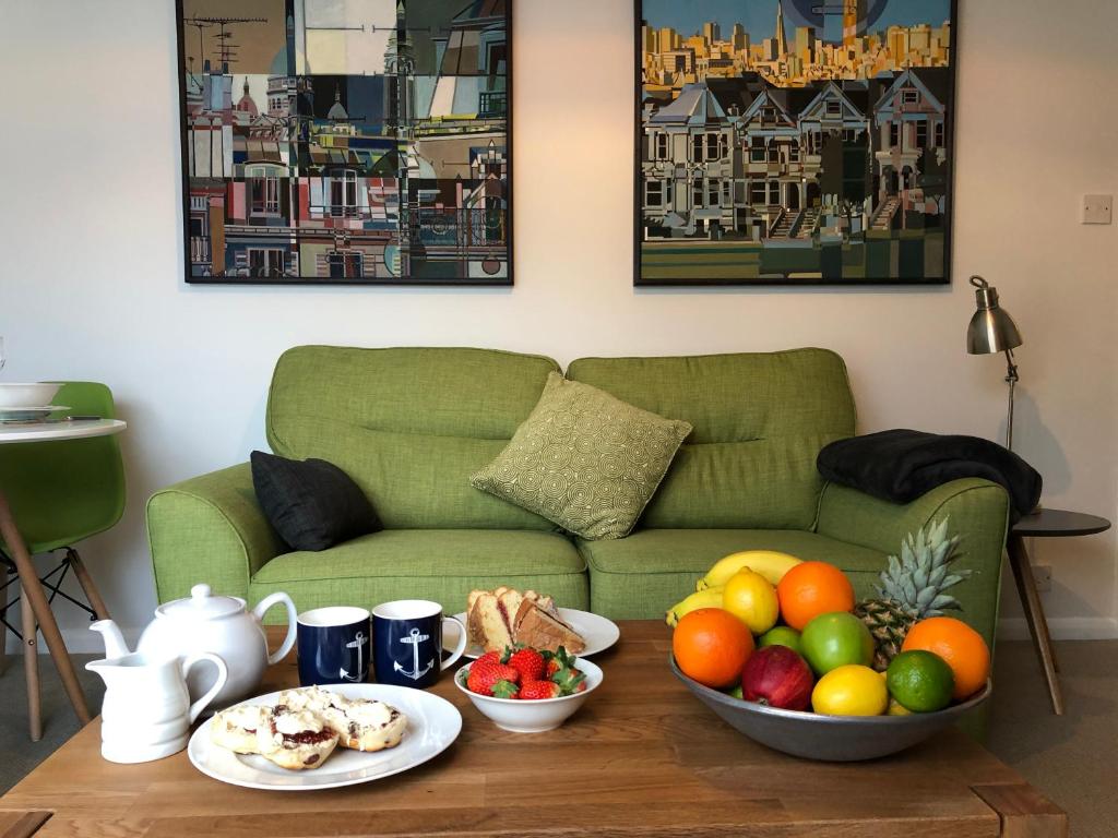a coffee table with a bowl of fruit and a couch at Coast Apartment in Sidmouth