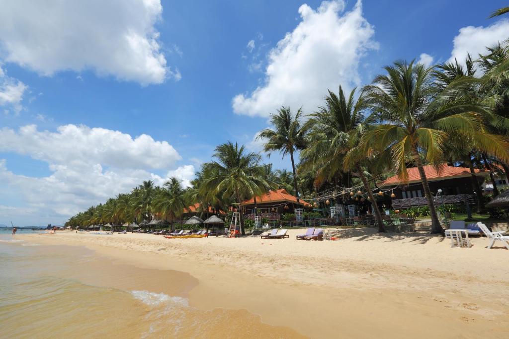 a beach with palm trees and palm trees at Saigon Phu Quoc Resort & Spa in Phú Quốc