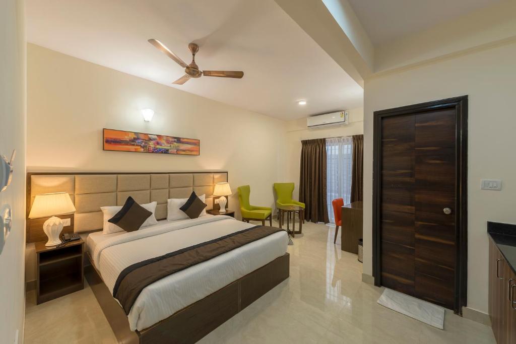 a bedroom with a bed and a table and chairs at Daffodil Delight - Manyata Tech Park in Bangalore