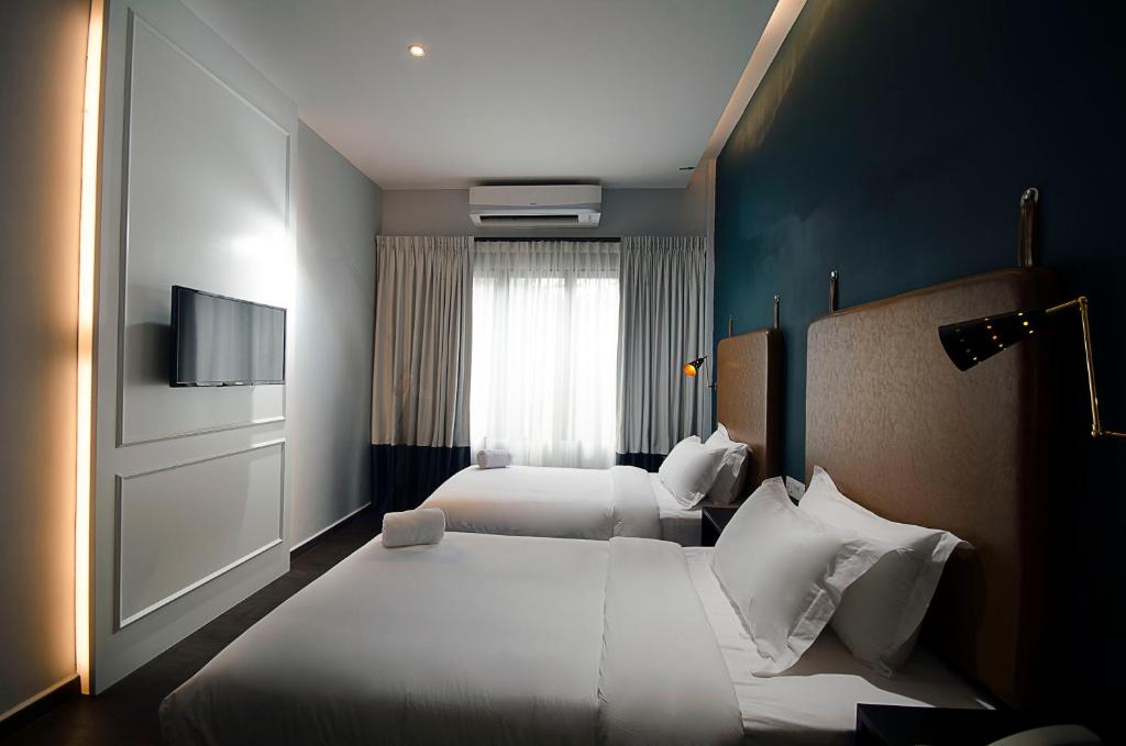 Postel nebo postele na pokoji v ubytování Palm Hotel Ipoh