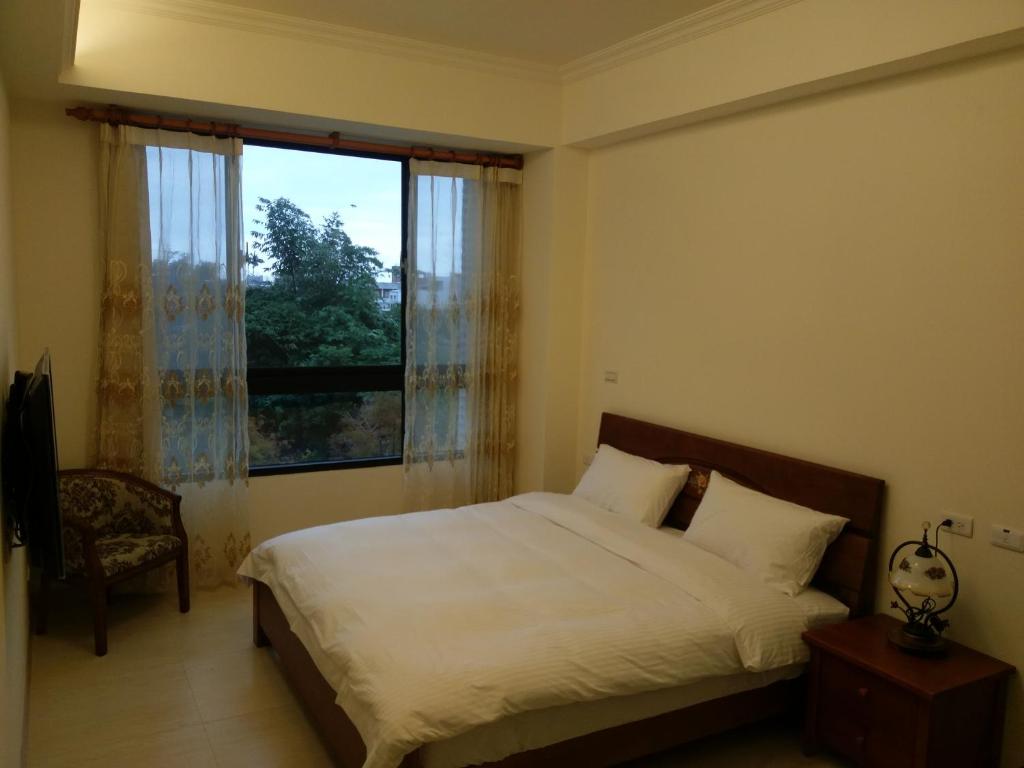 a bedroom with a bed and a large window at Dolphin Love Homestay in Jian