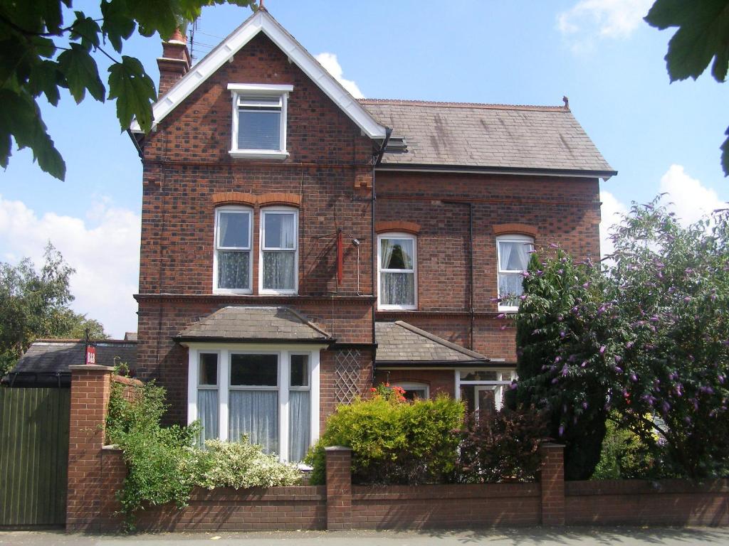 a brick house with a fence in front of it at Anton Guest House Bed and Breakfast in Shrewsbury