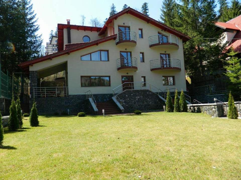 a large house with a lawn in front of it at Casa Cristian in Sinaia