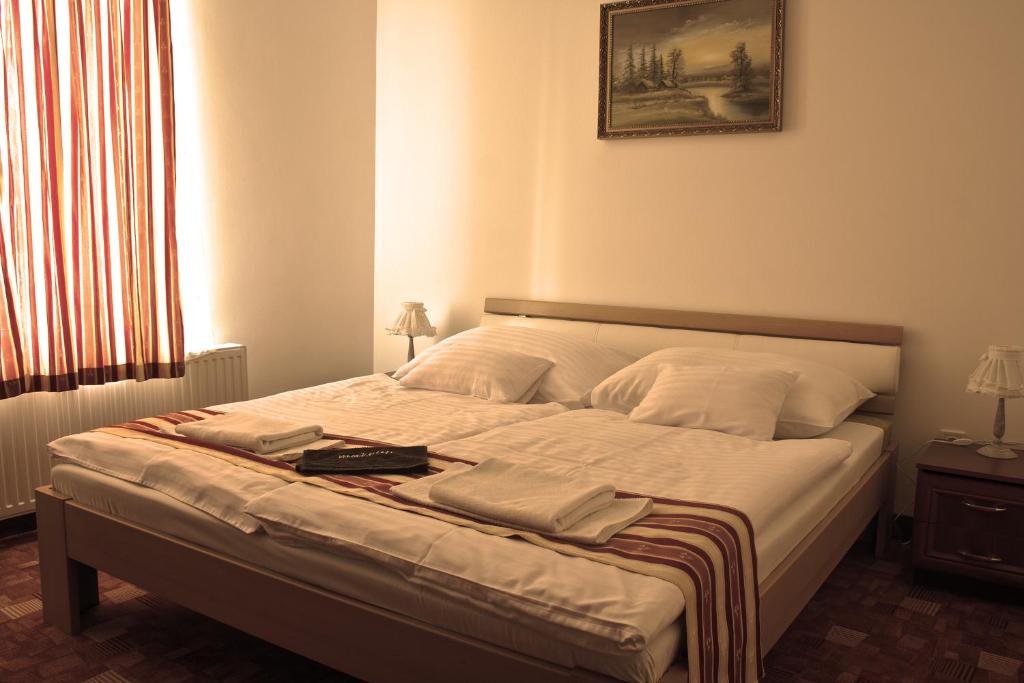 A bed or beds in a room at Centrum Panzió
