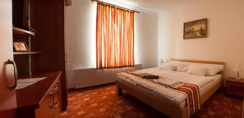 A bed or beds in a room at Centrum Panzió
