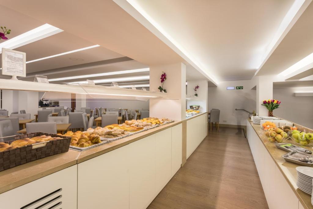 a cafeteria with a buffet line with food at Hotel Londres Estoril / Cascais in Estoril