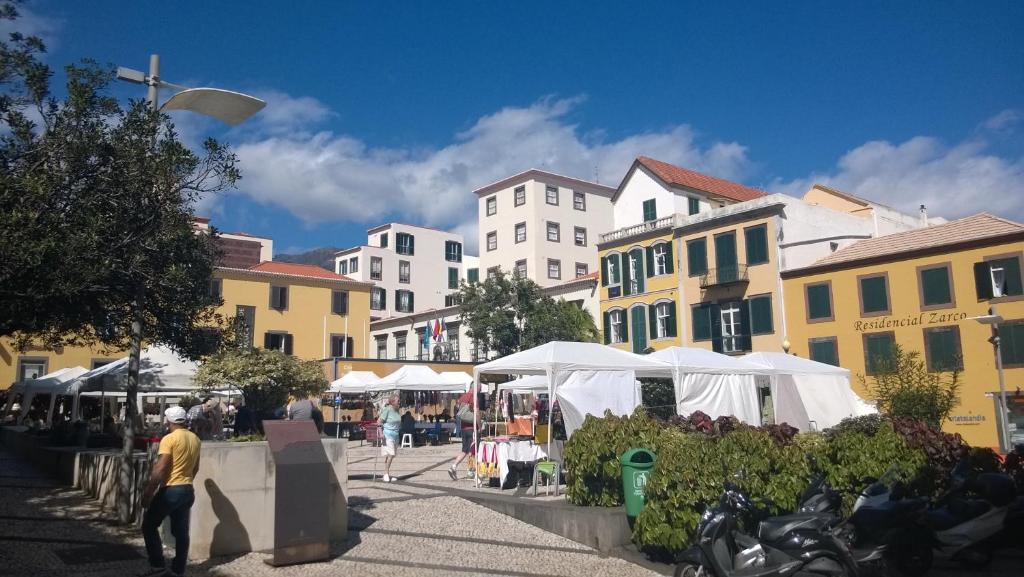 un marché dans une ville avec des tentes et des bâtiments blancs dans l'établissement Central Suite in Funchal 3N, à Funchal