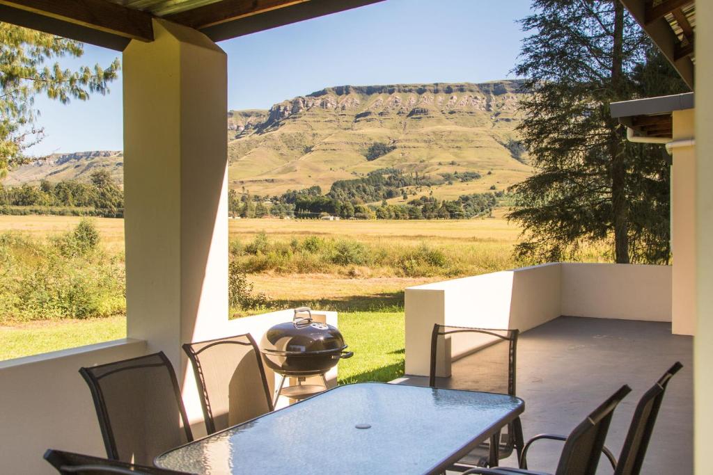 a patio with a table and chairs and a grill at Kamberg Valley Hideaway in Kamberg Valley