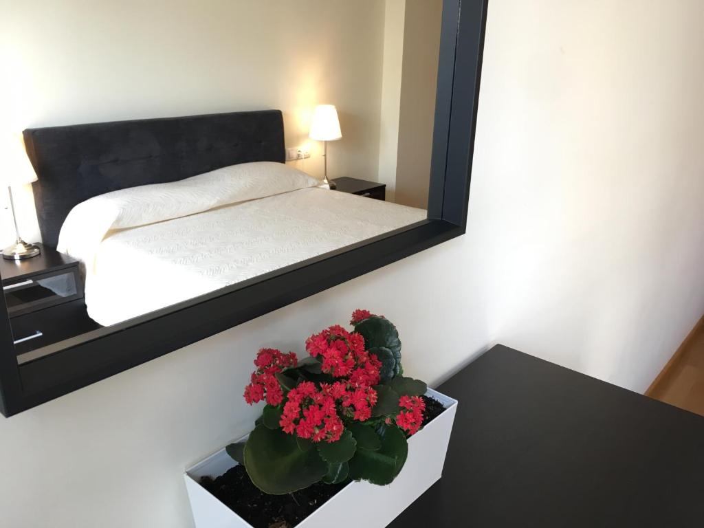 a bedroom with a mirror and a table with flowers at Sun Apartament Valencia @ City Arts & Sciences + Parking in Valencia