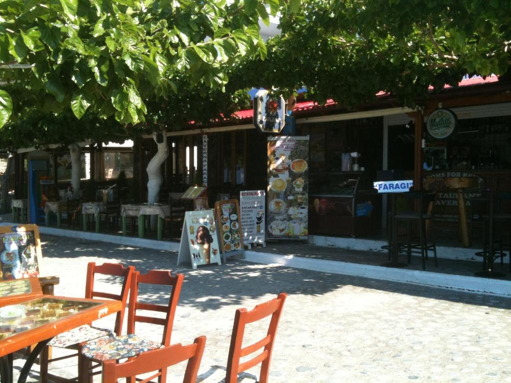a restaurant with tables, chairs, and tables with umbrellas at Faragi in Agia Roumeli