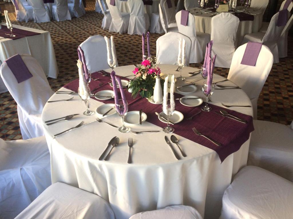 a table with a white table cloth and silverware at Panamericana Hotel Ancud in Ancud