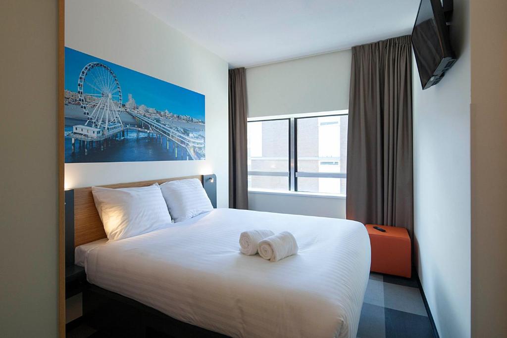 een hotelkamer met een bed met een handdoek erop bij easyHotel The Hague Scheveningen Beach in Scheveningen