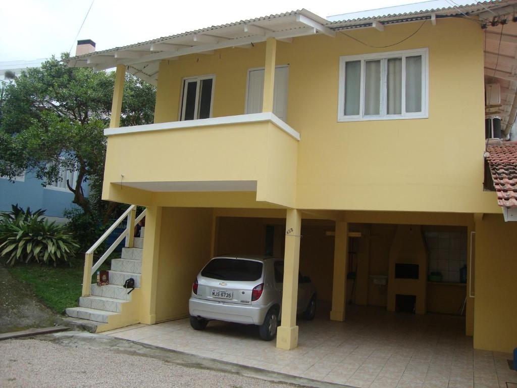 una casa amarilla con un coche aparcado en el garaje en Casa de 2 quartos no Centro de Bombinhas, en Bombinhas