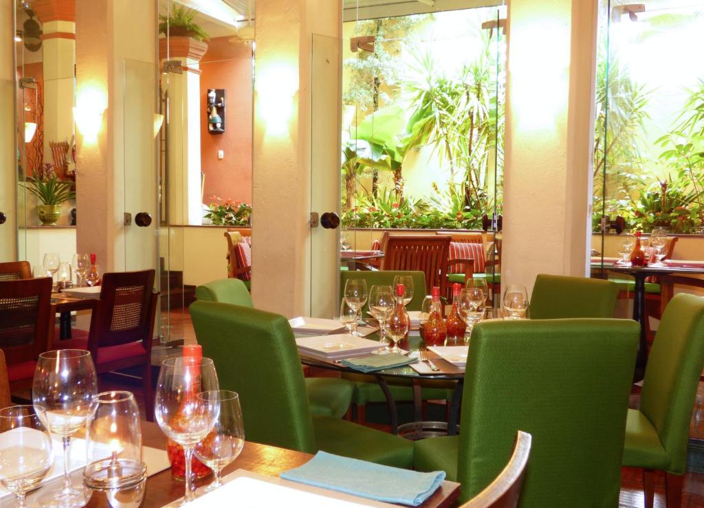 a restaurant with tables and chairs with wine glasses at Hotel Casa do Amarelindo in Salvador