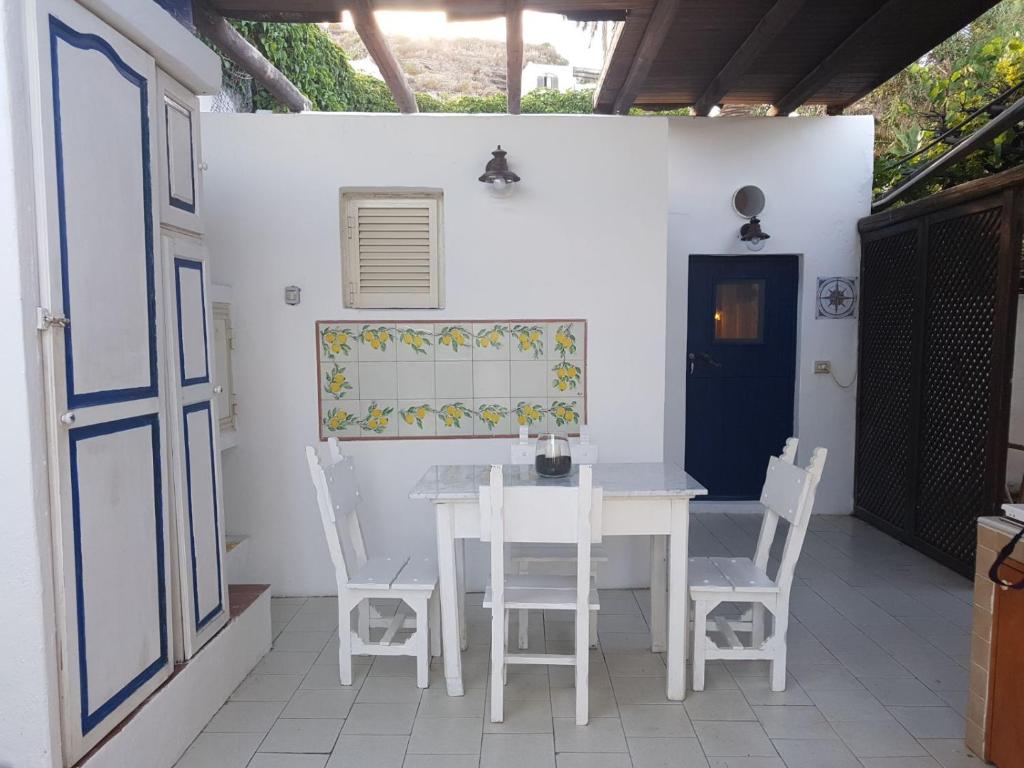 een witte tafel en stoelen op een patio bij Con i piedi nell'acqua in Stromboli