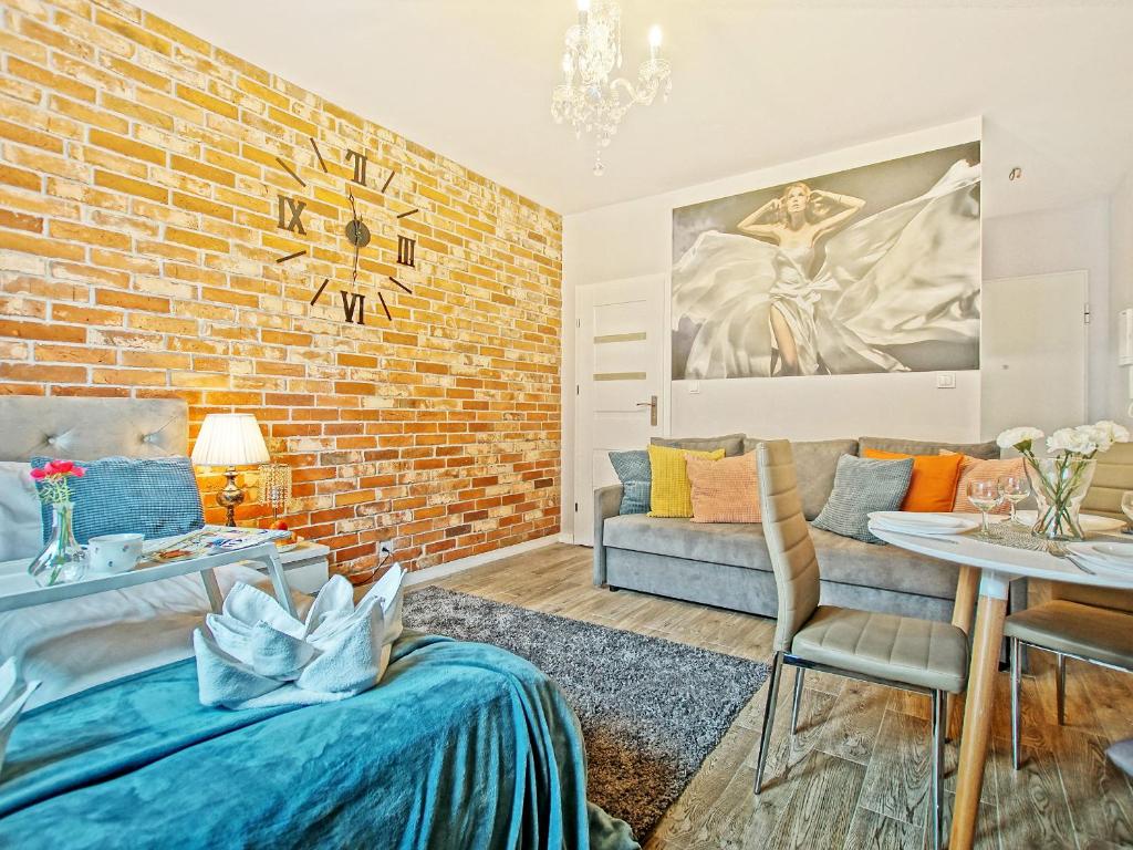 a living room with a brick wall at Apartament Starogdański 6 in Gdańsk