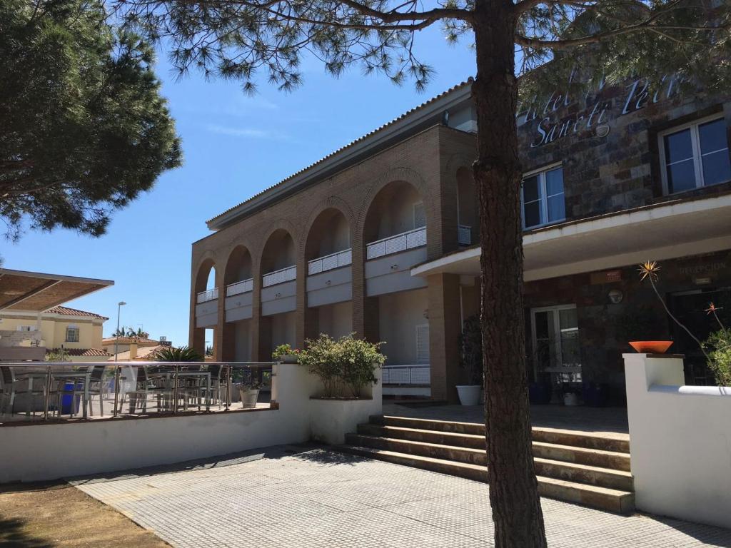a building with a tree in front of it at Hotel Marisma Sancti Petri in Chiclana de la Frontera