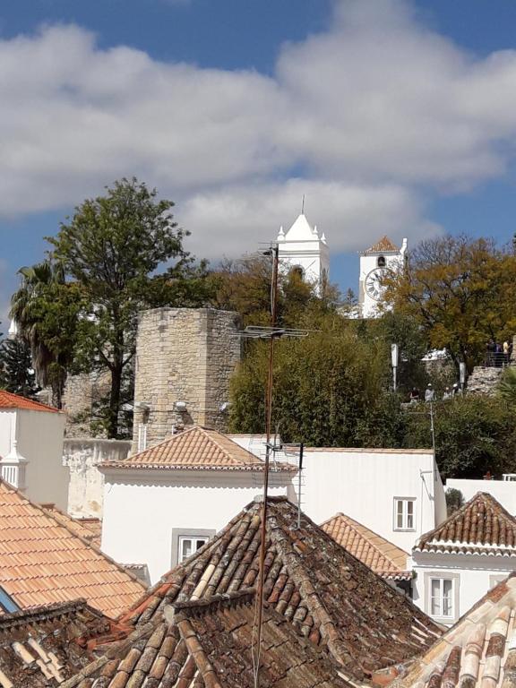 - une vue sur les toits d'une ville avec une tour d'horloge dans l'établissement Tavira Downtown Calm House, à Tavira