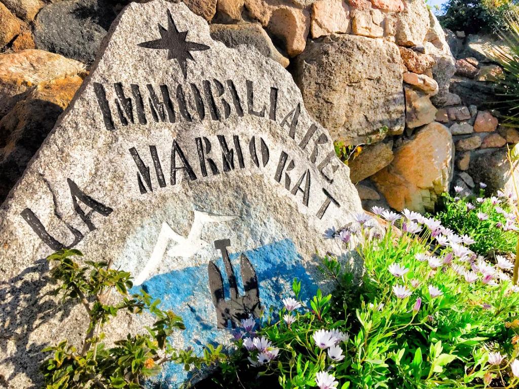 un signe en pierre pour un signe marmite sur un mur de roche dans l'établissement Residence La Marmorata - IUN F0146 -, à Santa Teresa Gallura