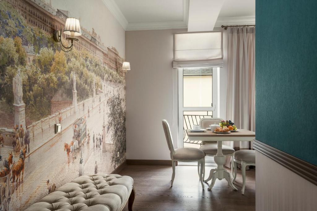 a dining room with a table and a painting on the wall at ZENTRUM Hotel in Chişinău