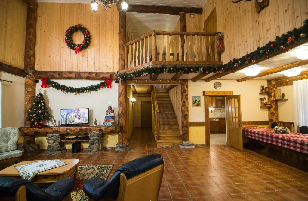 een woonkamer met een kerstboom en een trap bij Seventh Heaven in Mykulychyn