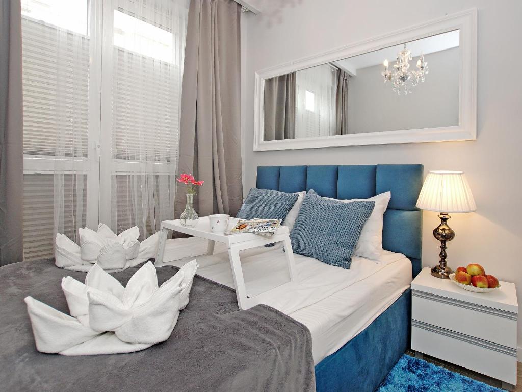 a bedroom with a blue and white bed and a table at Apartament Starogdański 7 in Gdańsk