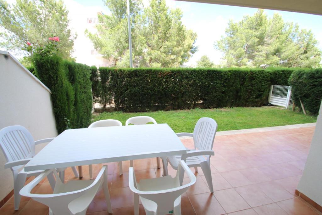 ミアミ・プラトーヤにあるApartamento Villa Jardinのパティオ(白いテーブル、椅子付)