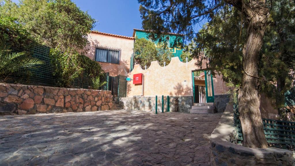 a building with a tree in front of a street at Sadeem Village & Chalet in Al Shafa