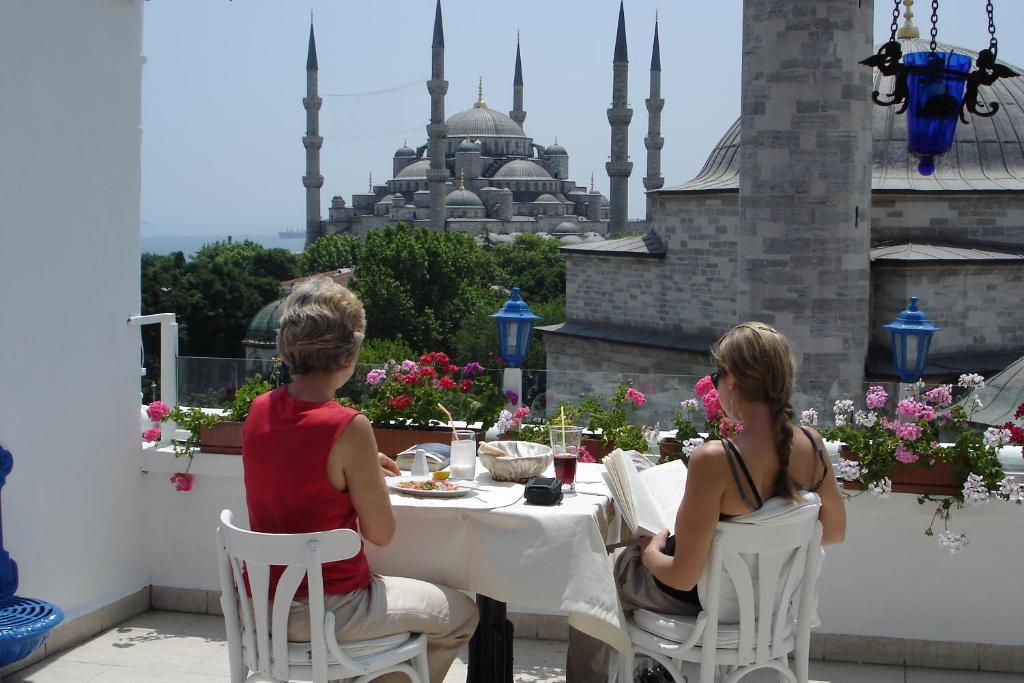 a boy and a girl sitting at a table on a balcony at Hotel Sultanahmet in Istanbul