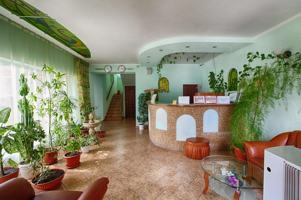 un hall avec une bande de plantes en pot dans l'établissement Motel Uyut, à Krutinka