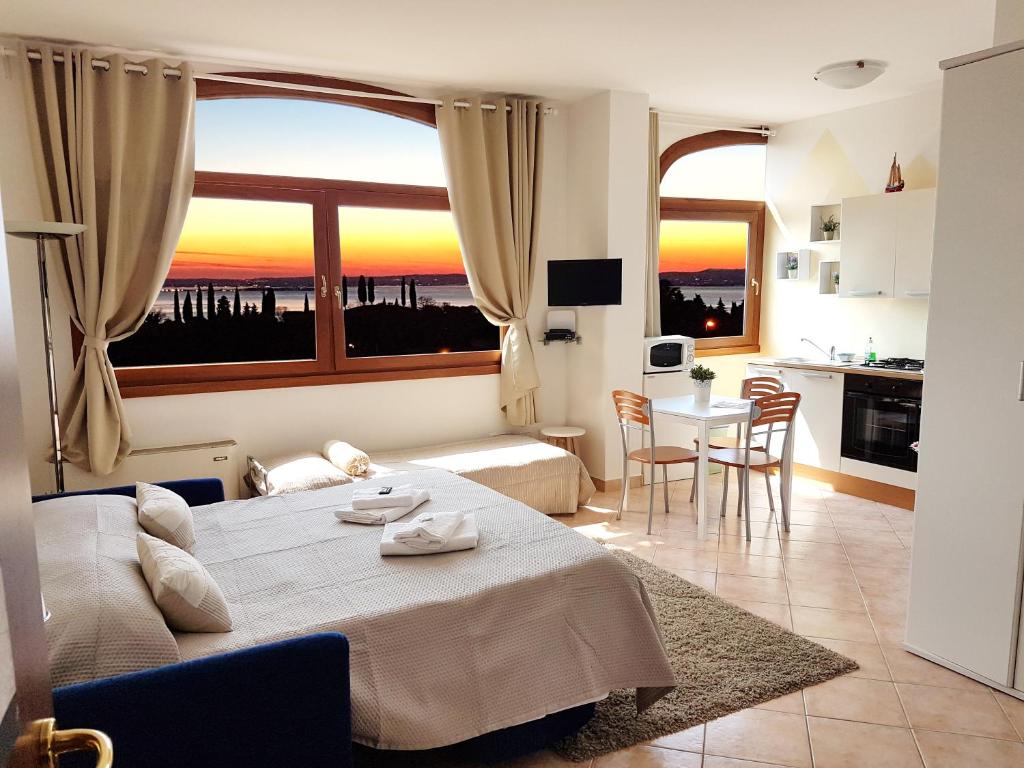 カヴァイオーン・ヴェロネーゼにあるHome Suite Homeのベッドと大きな窓が備わるホテルルームです。