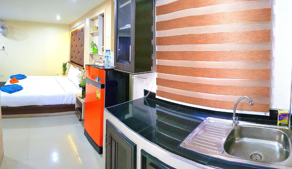 uma cozinha com um lavatório e uma cama num quarto em Walking Street Residence - Boutique Suites near the Beach & Walking Street em South Pattaya