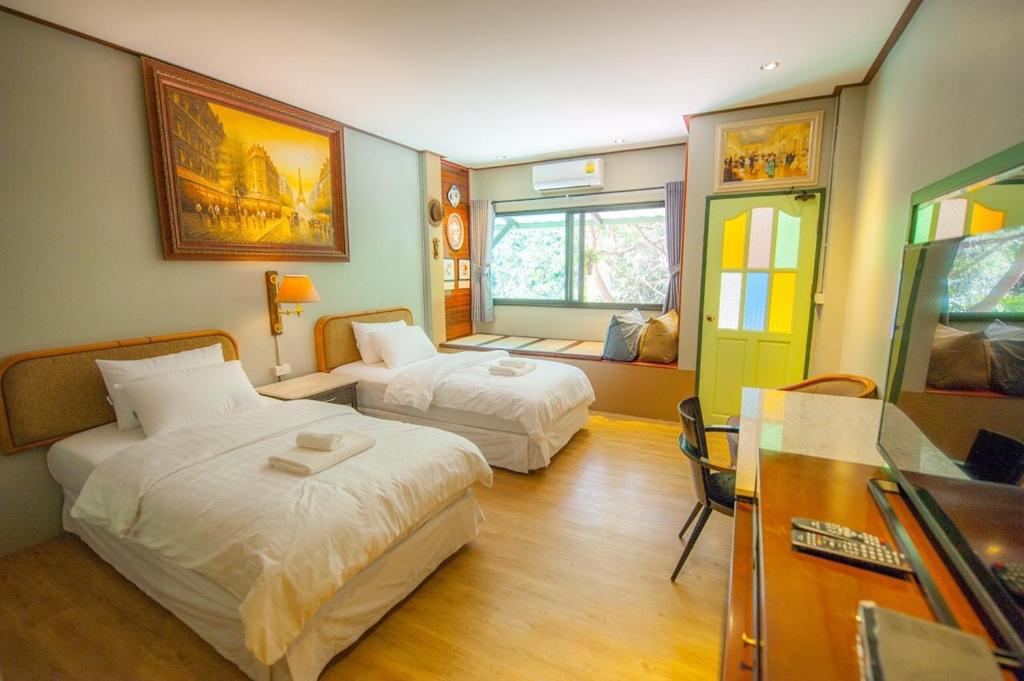 ein Hotelzimmer mit 2 Betten und einem Fenster in der Unterkunft Ban Mai Vintage in Pak Chong