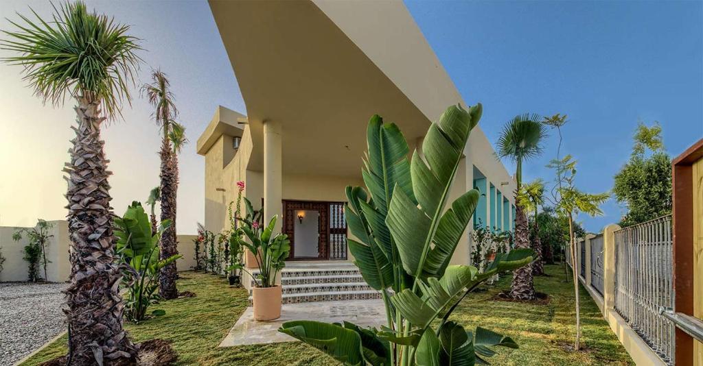 une maison avec des palmiers devant elle dans l'établissement Sahaba Zahora, à Zahora
