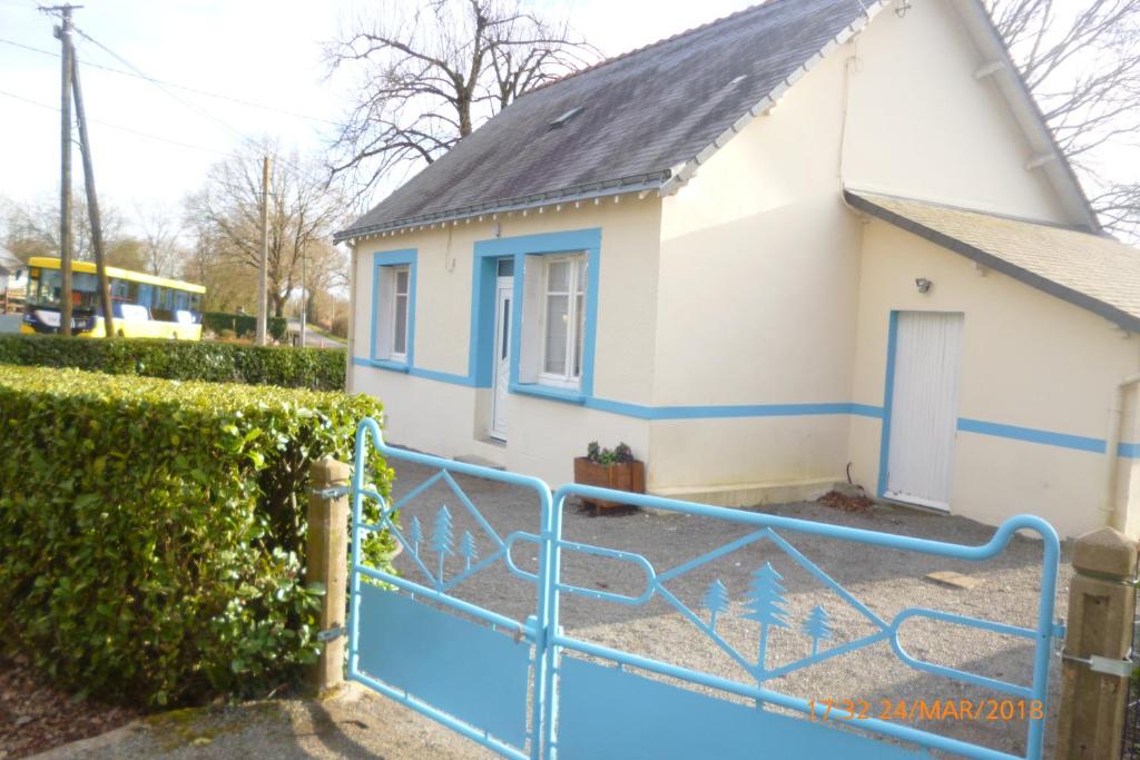 una casa con una puerta azul delante de ella en ty jeanette, en Missillac