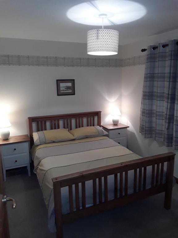 a bedroom with a large bed and two night stands at The Pally - behind 13 Palace Road, Kirkwall, Orkney - STL OR00122F in Kirkwall
