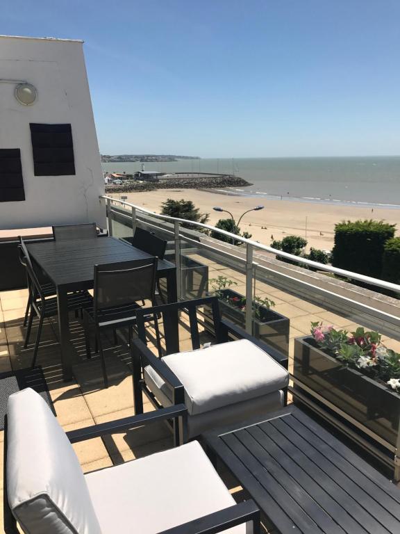 a balcony with a table and chairs and the beach at Appartement à royan in Royan