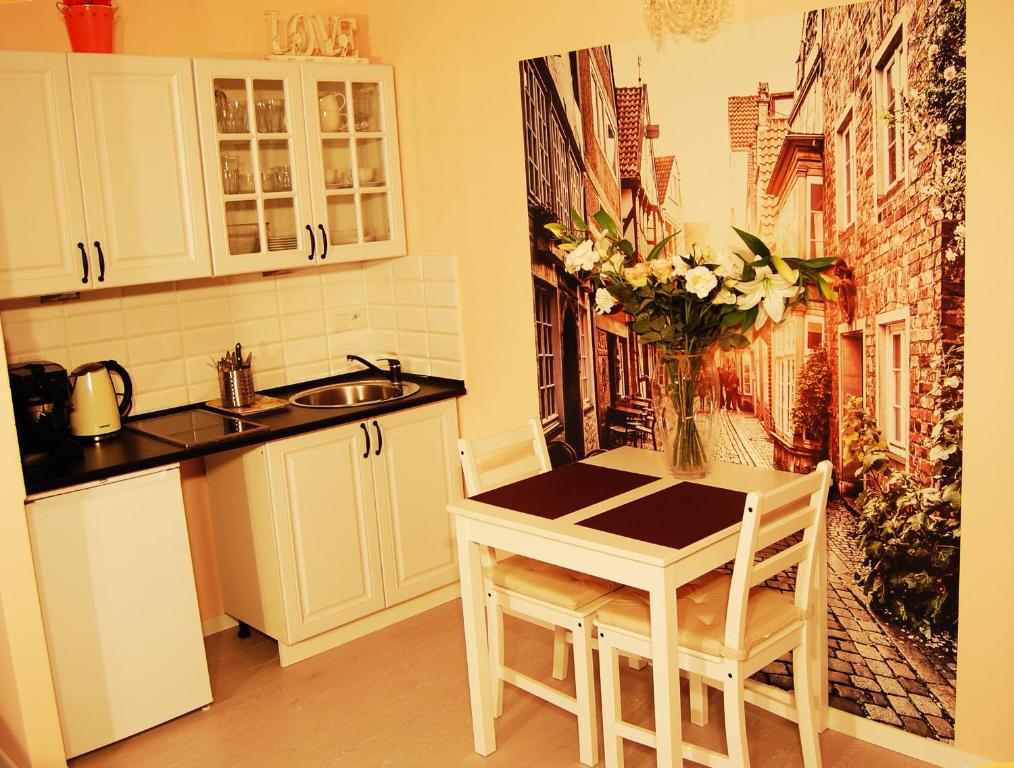 una cocina con una mesa con un jarrón de flores en Oranger Studio, en Kielce